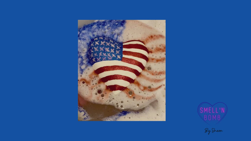 Video of the Big beautiful heart bath bomb with the American flag painted on it releasing in the water.